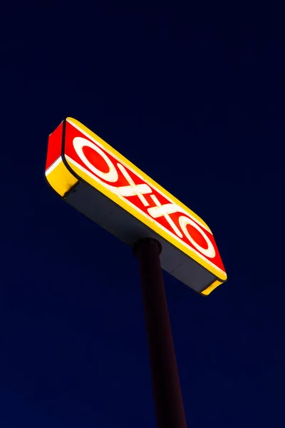 Ramos Arizpe, Coahuila, Meksika - 22 Ocak 2025 - Koyu mavi gökyüzü arkaplanlı parlak oxxo işareti