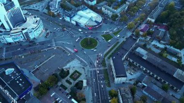 İnsansız hava aracı görüntüleri modern bir şehir kavşağında ve alacakaranlıkta geniş caddelerde hareket eden arabaları gösteriyor. Ulaşım, iş veya kentsel kalkınma kavramları için temiz hava görüşü ideal. 