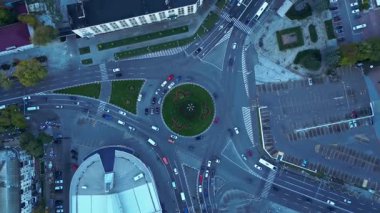 Akşam ışığında şehirde yoğun bir trafik kavşağının insansız hava aracı görüntüsü. Arabalar düzenli altyapı ve modern şehir hareketlerini gösteren sorunsuz bir şekilde dolaşıyorlar.. 