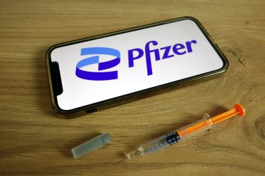 KONSKIE, POLAND - 9 Haziran 2021: Pfizer Inc şirket logosu şırıngayla cep telefonunda sergilendi. Covid-19 aşı konsepti