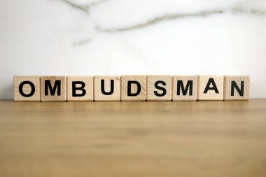 Ombudsman word from wooden blocks on desk, public administration concept clipart