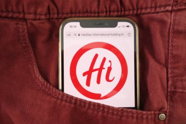 KONSKIE, POLAND - 17 Ağustos 2021: Haidilao International Holding Ltd logosu kot pantolon cebinde saklı cep telefonunda sergilendi