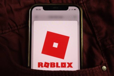 KONSKIE, POLAND - 17 Ağustos 2021: Roblox çevrimiçi oyun platformu logosu kot pantolon cebine gizlenmiş cep telefonunda görüntülendi