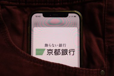 KONSKIE, POLAND - 04 Eylül 2021: Kyoto Ltd bankası logosu kot pantolonun cebine gizlenmiş cep telefonunda görüntülendi