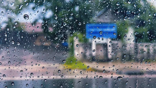 Yağmurlu bir günde araba camına yağmur damlaları Bulanık Sokak Arkaplanlı yağmur damlaları