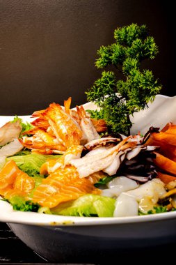 Wasabi, zencefil ve soya sosu gibi garnitürlerle servis edilen taze sashimi dilimlerinin enfes bir fotoğrafı. Canlı renkler, zarif bir sunum ve taze malzemeler iştah açıcı bir Japon mutfağı yaratıyor. Mutfak ve yemek fotoğrafçılığı için mükemmel.