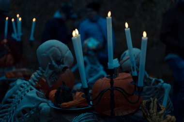 Cadılar Bayramı. Karanlık arka planda kafatası ve kemikleri olan ürkütücü cadılar bayramı iskeleti Cadılar Bayramı gecesi için ürkütücü bir şekilde ışıldayan korku dekorasyonu..