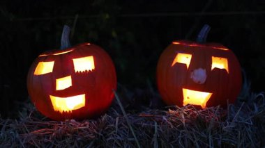 Cadılar Bayramı. Işıl ışıl Cadılar Bayramı balkabakları (kriko-fenerler) gecenin karanlığında içinde titreyen mumlar, ürkütücü ve şenlikli sonbahar atmosferi, 4K ultra HD görüntü.