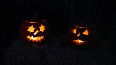 Cadılar Bayramı. Işıl ışıl Cadılar Bayramı balkabakları (kriko-fenerler) gecenin karanlığında içinde titreyen mumlar, ürkütücü ve şenlikli sonbahar atmosferi, 4K ultra HD görüntü.