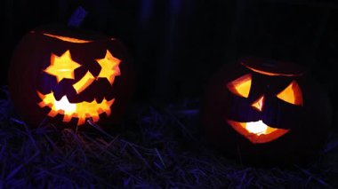 Cadılar Bayramı. Işıl ışıl Cadılar Bayramı balkabakları (kriko-fenerler) gecenin karanlığında içinde titreyen mumlar, ürkütücü ve şenlikli sonbahar atmosferi, 4K ultra HD görüntü.