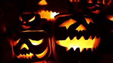 Cadılar Bayramı. Işıl ışıl Cadılar Bayramı balkabakları (kriko-fenerler) gecenin karanlığında içinde titreyen mumlar, ürkütücü ve şenlikli sonbahar atmosferi, 4K ultra HD görüntü.