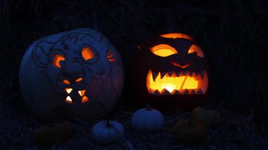 Cadılar Bayramı. Işıl ışıl Cadılar Bayramı balkabakları (kriko-fenerler) gecenin karanlığında içinde titreyen mumlar, ürkütücü ve şenlikli sonbahar atmosferi, 4K ultra HD görüntü.