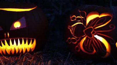 Cadılar Bayramı. Işıl ışıl Cadılar Bayramı balkabakları (kriko-fenerler) gecenin karanlığında içinde titreyen mumlar, ürkütücü ve şenlikli sonbahar atmosferi, 4K ultra HD görüntü.