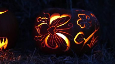 Cadılar Bayramı. Işıl ışıl Cadılar Bayramı balkabakları (kriko-fenerler) gecenin karanlığında içinde titreyen mumlar, ürkütücü ve şenlikli sonbahar atmosferi, 4K ultra HD görüntü.