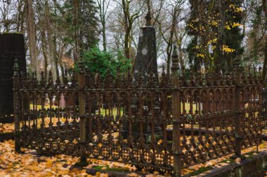 Geceleri mezarlıkta mumlar yakar, sıcak alevler mezarların arasında sakin ve duygusal bir anıt atmosfer yaratır..