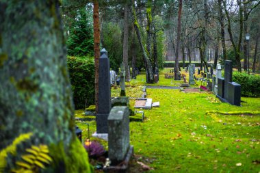 Geceleri mezarlıkta mumlar yakar, sıcak alevler mezarların arasında sakin ve duygusal bir anıt atmosfer yaratır..