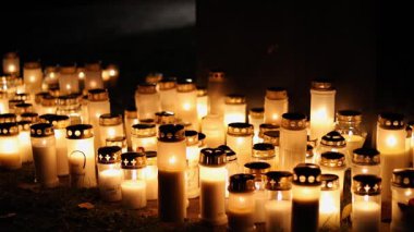 Sessiz bir mezarlıkta mumları yakmak, titreyen sıcak alevler mezar taşlarını yakmak ve 4K ultra HD ile yakalanan barışçıl bir anıt atmosferi yaratmak..