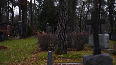 Sessiz bir mezarlıkta mumları yakmak, titreyen sıcak alevler mezar taşlarını yakmak ve 4K ultra HD ile yakalanan barışçıl bir anıt atmosferi yaratmak..