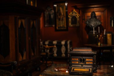 Antika mobilyalarla, taş duvarlarla ve sıcak ışıkla dolu eski bir şato. Tarih ve gizemle dolu bir ortaçağ atmosferi yaratıyor..