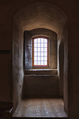 Antika mobilyalarla, taş duvarlarla ve sıcak ışıkla dolu eski bir şato. Tarih ve gizemle dolu bir ortaçağ atmosferi yaratıyor..