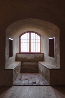 Antika mobilyalarla, taş duvarlarla ve sıcak ışıkla dolu eski bir şato. Tarih ve gizemle dolu bir ortaçağ atmosferi yaratıyor..