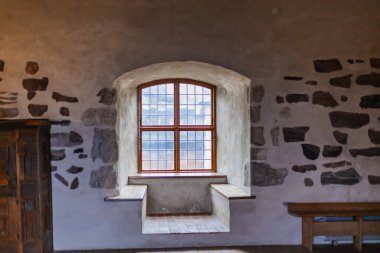 Antika mobilyalarla, taş duvarlarla ve sıcak ışıkla dolu eski bir şato. Tarih ve gizemle dolu bir ortaçağ atmosferi yaratıyor..