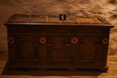 Ortaçağ şatosunun iç kısımlarına yerleştirilmiş eski ahşap sandıklar antika işçiliğini, eski dokuları ve tarihi ambiyansı gösteriyor..