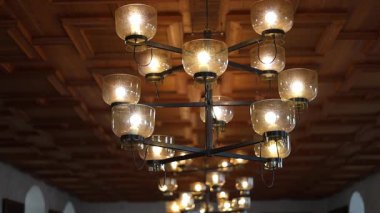 Uzun ahşap masalar, avizeler, taş duvarlar ve sıcak mum ışığı olan bir ortaçağ şatosu ziyafeti salonu. Kraliyet ziyafetlerinin görkemli tarihi atmosferi, 4K ultra HD ile yakalandı..