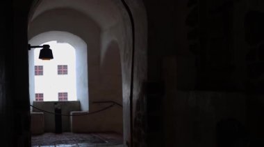 Taş duvarları, ahşap mobilyaları ve sıcak ışığı olan antik kale odaları. Ortaçağ mimarisinin tarihi atmosferi, 4K ultra HD 'de otantik detaylarla yakalanmış..