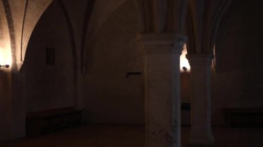 Taş duvarları, ahşap mobilyaları ve sıcak ışığı olan antik kale odaları. Ortaçağ mimarisinin tarihi atmosferi, 4K ultra HD 'de otantik detaylarla yakalanmış..