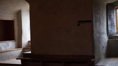 Taş duvarları, ahşap mobilyaları ve sıcak ışığı olan antik kale odaları. Ortaçağ mimarisinin tarihi atmosferi, 4K ultra HD 'de otantik detaylarla yakalanmış..