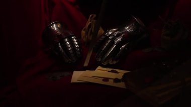 Ortaçağ tacı, eski bir mektup ve tahta bir masaya yerleştirilmiş bir kılıç. Tarihi ve kraliyet atmosferi yaratıyor. Dramatik ışıklandırma, 4K ultra HD ile yakalanan antika dokuları vurguluyor.