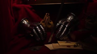 Ortaçağ tacı, eski bir mektup ve tahta bir masaya yerleştirilmiş bir kılıç. Tarihi ve kraliyet atmosferi yaratıyor. Dramatik ışıklandırma, 4K ultra HD ile yakalanan antika dokuları vurguluyor.