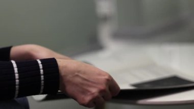 Bir dergiye göz gezdirirken, sayfaları yavaşça ve sorunsuzca çevirirken. Doğal ışıklandırma ile 4K ultra HD ile çekilmiş, kağıt dokusu, hareketi ve detayları gösteriyor. Yaşam tarzı videoları, reklamlar, okumalar için ideal