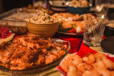 Noel veya yeni yıl kutlamaları için hazırlanmış çeşitli yemeklerle birlikte bir tatil masasında servis edilen şenlikli yemek fotoğrafı. Görüntü sıcaklığı, bolluğu ve neşeli aile geleneklerini aktarır..