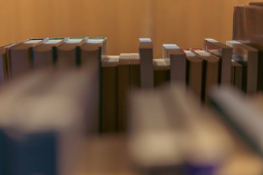 Sıralar dolusu kitap rafları kütüphane koridorunda sıcak ve davetkar bir atmosfer yaratıyor. Arka plan hafifçe bulanık ve bulanık....