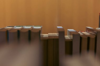 Sıralar dolusu kitap rafları kütüphane koridorunda sıcak ve davetkar bir atmosfer yaratıyor. Arka plan hafifçe bulanık ve bulanık....