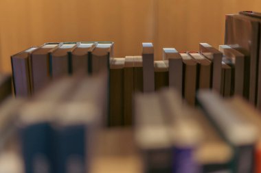 Sıralar dolusu kitap rafları kütüphane koridorunda sıcak ve davetkar bir atmosfer yaratıyor. Arka plan hafifçe bulanık ve bulanık....