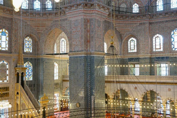 İstanbul, Türkiye 'deki Yeni Cami' nin (Yeni Cami) ayrıntılı bir iç çekimi. Görüntü, zarif kemerler, büyük merkezi bir kubbe ve çarpıcı turkuazla süslenmiş sütunlarla muhteşem İslami ve Osmanlı mimarisini vurguluyor. 