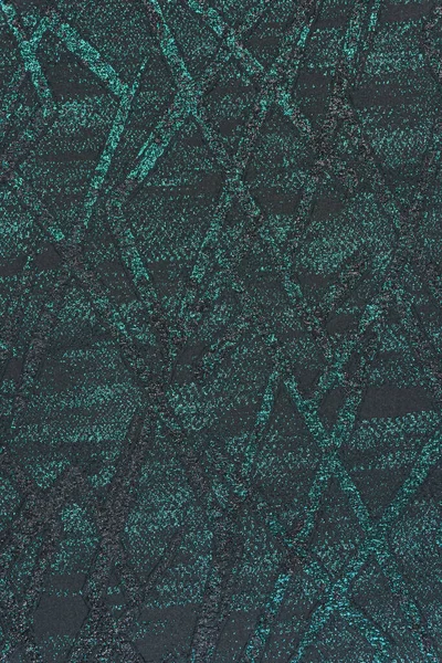 Kabartmalı, kadifemsi bir arka plan ve geometrik deseni var. Siyah bir baz, kesişen turkuaz ve siyah lureks çizgileri artı metalik noktalarla tamamlanır. Döşeme ve modern tasarım için kullan