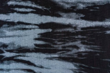 Mavi-gri ve siyah tonlarda soyut benekli desenli koyu dokuma bir tekstil yüzeyinin yakın çekimi. Modern moda veya grafik tasarımı için arkaplan