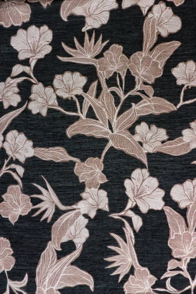 Ilık bej ve kahverengi tonlarda klasik bir çiçek motifi içeren koyu renkli kabarık kumaş dokusunun detaylı görüntüsü. Zarif dijital modeller için arkaplan