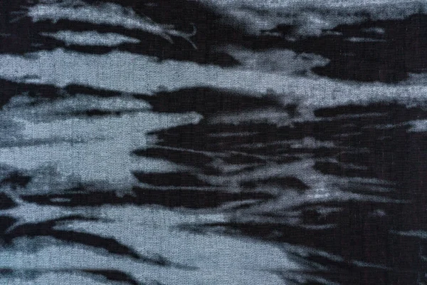 Mavi-gri ve siyah tonlarda soyut benekli desenli koyu dokuma bir tekstil yüzeyinin yakın çekimi. Modern moda veya grafik tasarımı için arkaplan