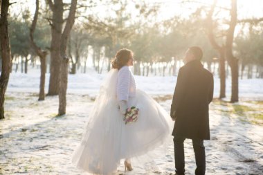 Gelin ve damat kış ormanında yürüyorlar.