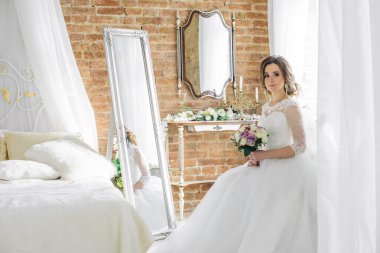 Güzel bir odada, beyaz bir elbise içinde bir buketle gelin.