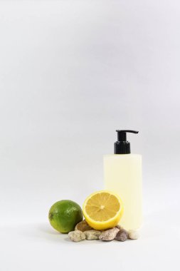 Doğal narenciye şampuanı ya da taze limon ve limonla pompa şişesinde vücut yıkamanın minimalist hayat tarzı fotoğrafı. Günlük kişisel bakım konsepti, çevre dostu kozmetik, temiz güzellik, sağlık ve beyaz arka planda tazelik