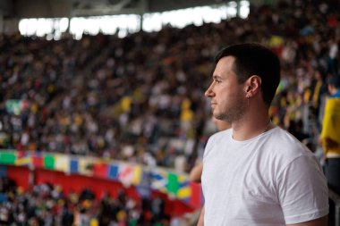 Dsseldorf, Almanya 21 Haziran 2024: Beyaz tişörtlü adam Merkur Spiel-Arena Stadyumu 'nda UEFA EURO 2024 futbol maçı Slovakya-Ukrayna maçını izliyor. Avrupa Şampiyonası maçında arka planda hayranlar var. Sadece editör kullanımı.