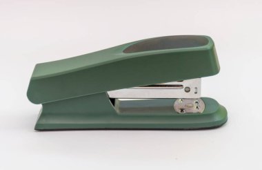 Metal parçalı modern yeşil ofis zımbası, iş aletlerini ve organizasyonu temsil eden, sade beyaz bir arka plana yerleştirilmiş..