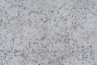 Gözenekleri, küçük eklentileri ve arka plan projeleri için doğal yüzey düzensizlikleri olan pürüzlü grimsi beton dokusu.