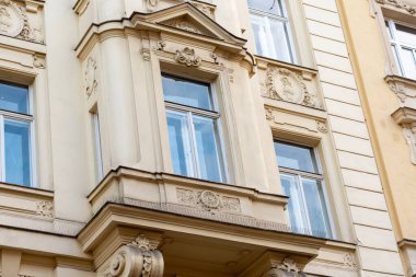 Pencereleri ve pervazları klasik tarzda olan tarihi bir Avrupa binasının dekoratif cephesi.